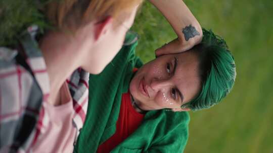 垂直视频一个穿着绿色衬衫的绿色短发女同性