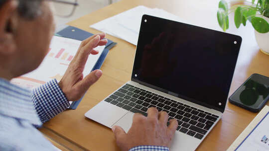 资深混血男子坐在家里使用笔记本电脑进行视频通话的视频，在屏幕上复制空间