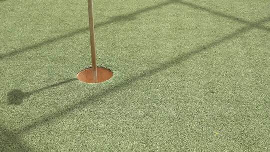 高尔夫球手在迷你高尔夫球场用几杆将高尔夫