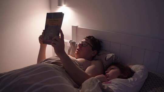 成人晚上和孩子在床上看书