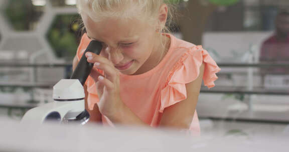快乐的高加索女孩在上课时用显微镜的视频