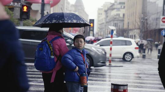 母子下雨天撑伞过马路上海南京路红绿灯