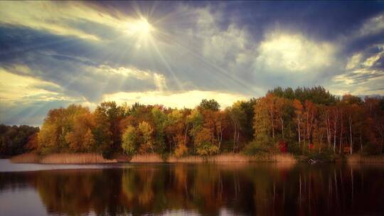 秋天阳光穿透乌云照在森林与湖泊