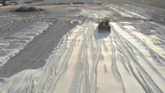 挖掘机用沙子平整场地，从土堆中移动沙子