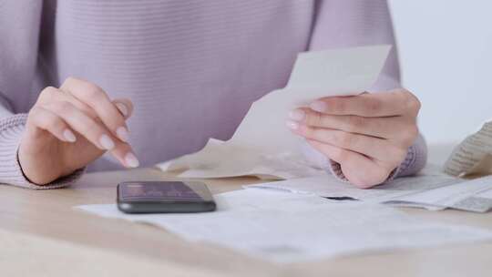 经济型女性在家用电话计算器工作在小工具在线上支付账单税公积金女性