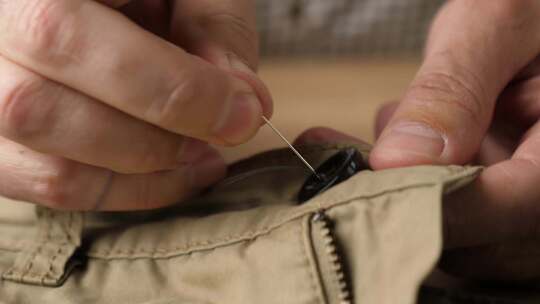 09.纽扣用针线手工缝在衣服上。小家务。视频素材模板下载