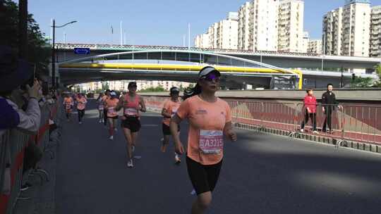 城市马拉松比赛中奔跑的女选手视频素材模板下载