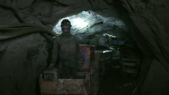 矿工开着小火车运输开采完成的原矿矿石