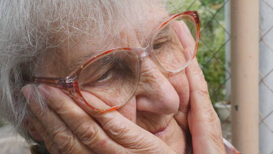 老奶奶戴着眼镜托腮沉思视频素材模板下载
