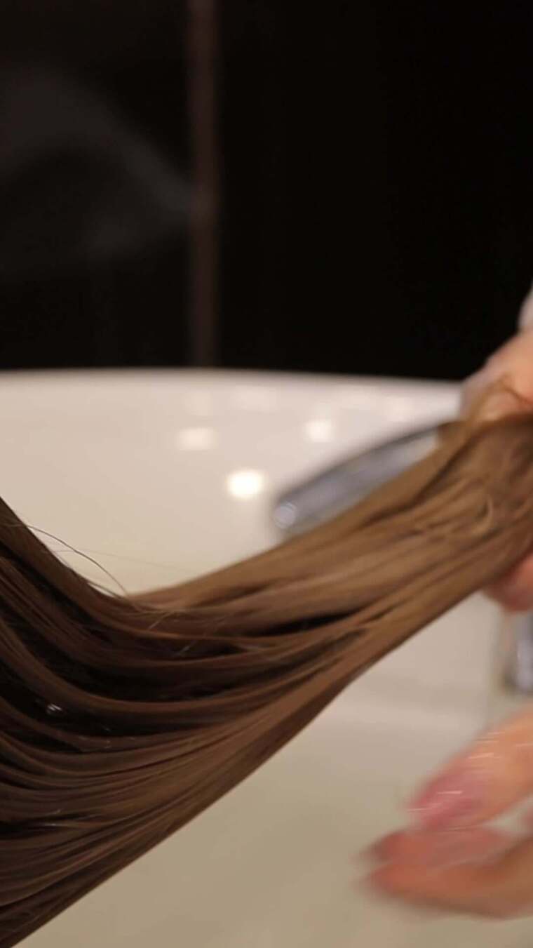 美容院垂直视频中洗脸盆里女人头发的特写