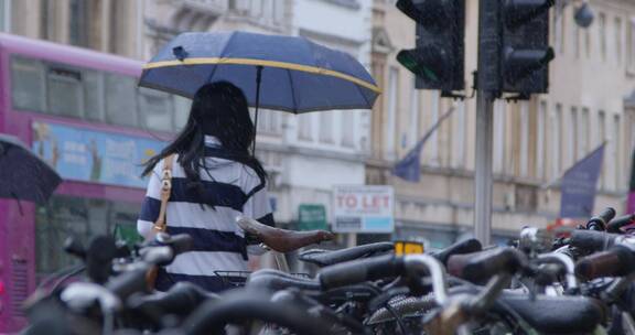 低角度拍摄打着雨伞的女人背影