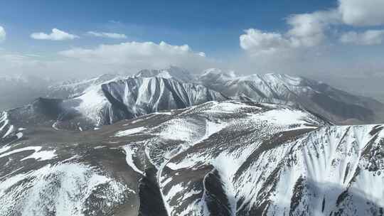 航拍蓝天白云下的新疆喀什地区雪山风光