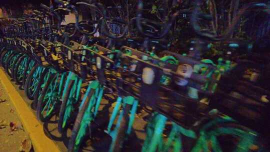 夜晚马路旁边停放的共享单车夜景视频素材视频素材模板下载