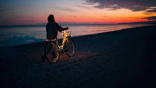夕阳下海滩上推着自行车