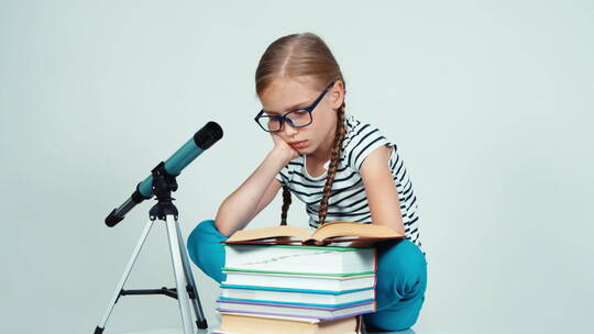 坐在望远镜边看书的戴眼镜女孩