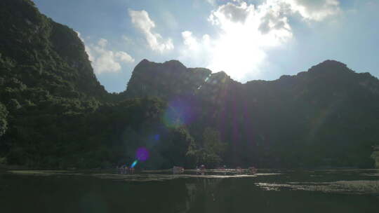 越南下龙湾小岛上的太阳和旅游船航行