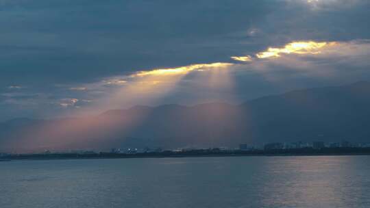 日本镰仓湾上空，太阳透过云层落下