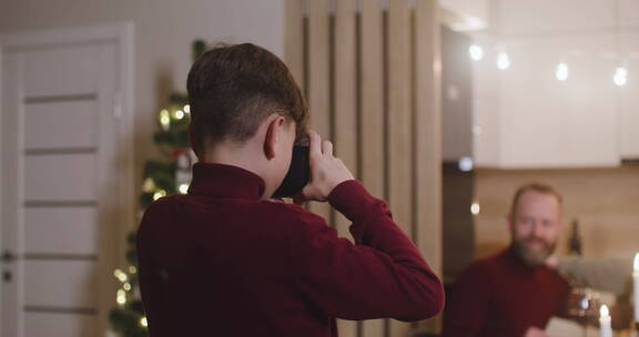 男孩使用手机给家人拍合影