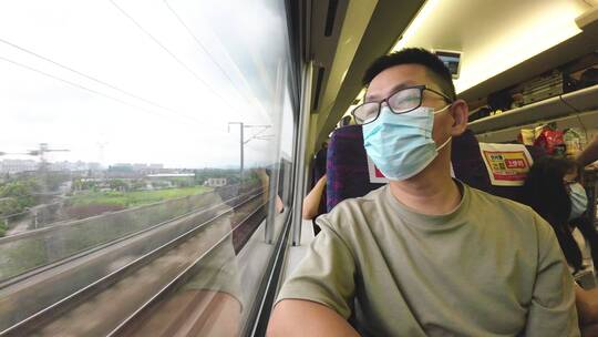 新冠病毒疫情中年男性乘客在高铁上看窗外