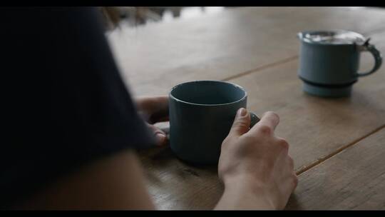 女人端起杯子喝茶