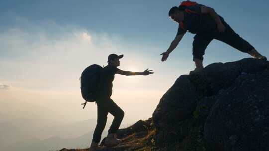 男人拉手登山团队合作