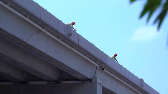 烈日下两名工人在作业路桥建设施工