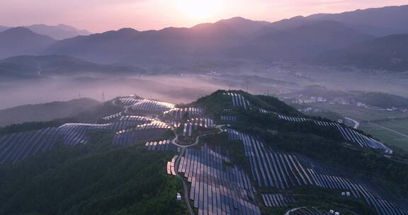 新能源太阳能光伏发电站夕阳下山坡航拍