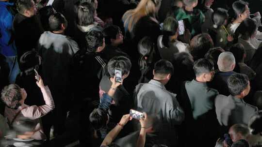 夜色广场音乐会，拥挤的观众现场手机拍照