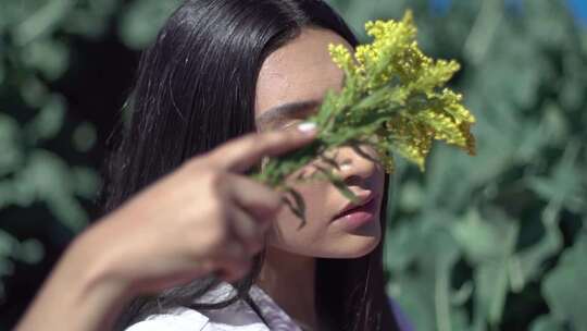 女子手持黄花在脸前