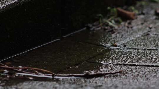 下雨天雨滴落在路面溅起水花