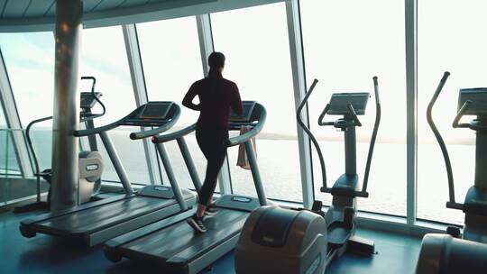 女人在健身房跑步机上跑步