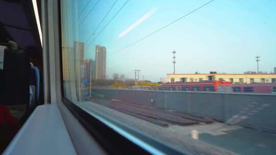 火车车厢内窗外列车与城市景象