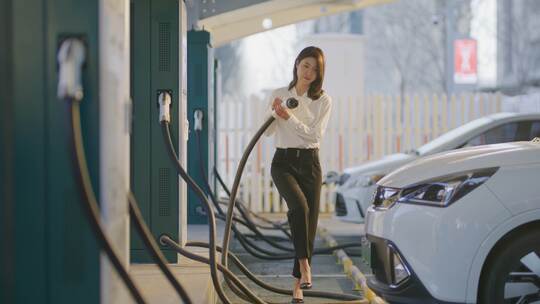 女士在国家电网充电桩为她的电动汽车充电视频素材模板下载