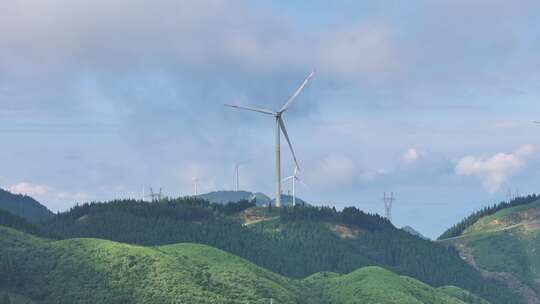 绿色山丘上的风力发电机群全景