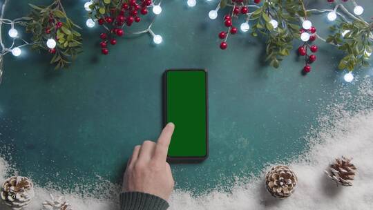 放在圣诞卓上的绿屏手机