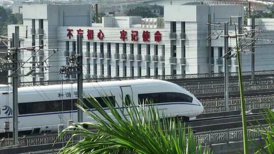 和谐号高铁行驶于建筑物旁