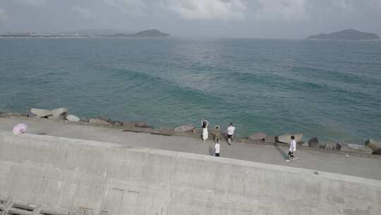 海边堤坝上的人们 海南 神州半岛 灯塔