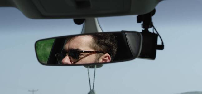 从反光镜中看男人驾驶汽车