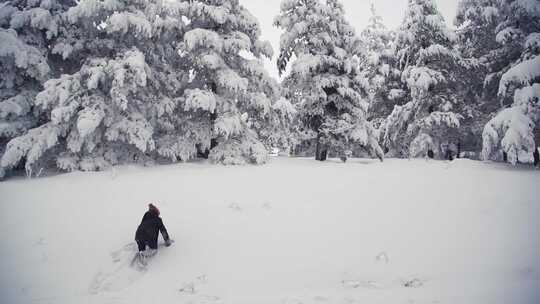 男孩试图在雪地里爬。