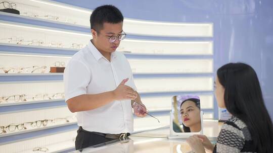眼镜店男验光师为年轻女顾客选购眼镜服务