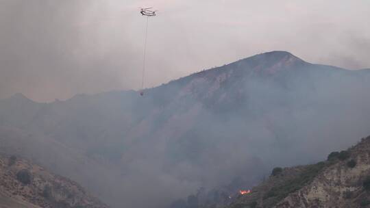 直升机在起火的森林上空灭火