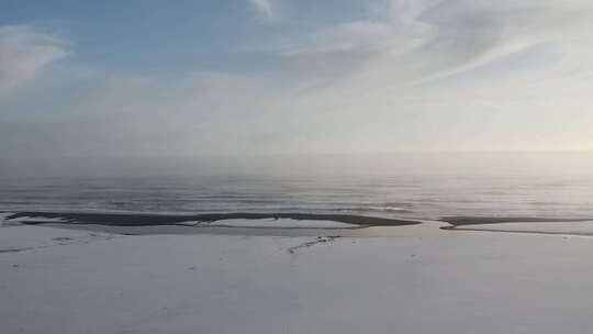 冰岛黑色玄武岩海滩被雪覆盖。大西洋的波浪