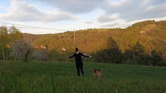 女人和她的狗在草地上开心玩耍