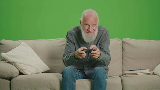 绿屏一个灰色胡子的老人用操纵杆玩电脑游戏视频素材模板下载