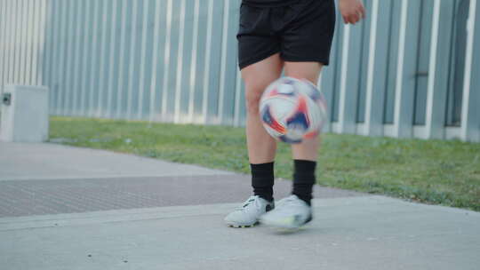 女孩在城市街道上练习玩足球杂耍视频素材模板下载