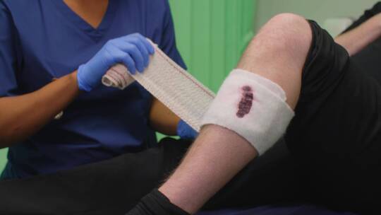 护士给病人包扎流血受伤的腿视频素材模板下载