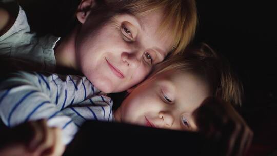 夜晚母子躺在床上使用平板视频素材模板下载