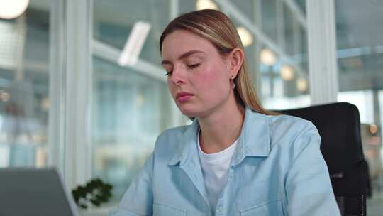 疲惫的妇女坐在工作区试图缓解头部疼痛
