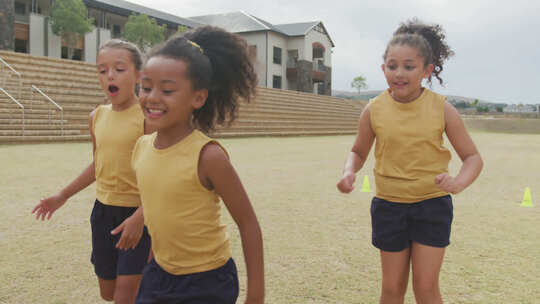 快乐的多样化女孩在学校前踢足球的视频