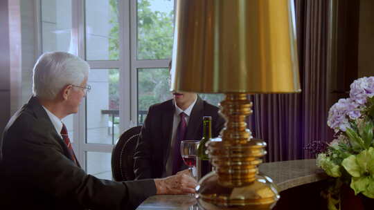 两位男士在室内品酒交谈